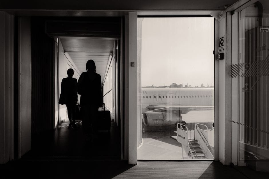 Silhouetted travelers walking through an airport terminal