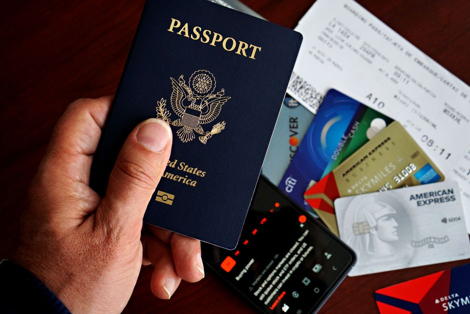 Dansk pas og boardingkort foran skærm med online rejsetilladelse til USA