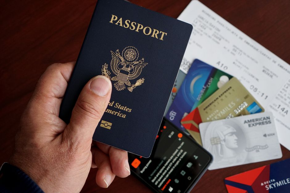 Person udfylder ESTA-ansøgning til USA på bærbar computer med pas ved siden
